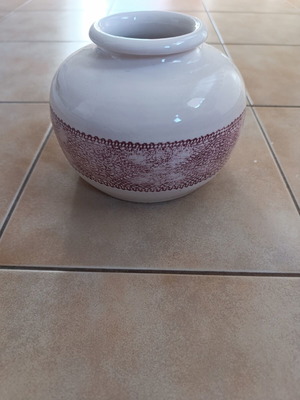 Ceramic decorative vase with white glossy surface and red lace pattern