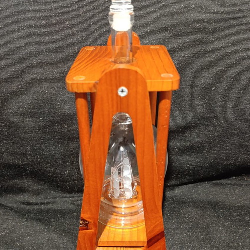 Vintage glass decanter with ship inside on wooden base, used