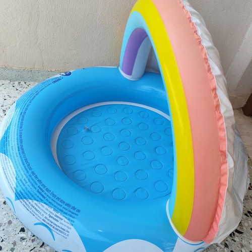 Blue children's pool with canopy used, rainbow design