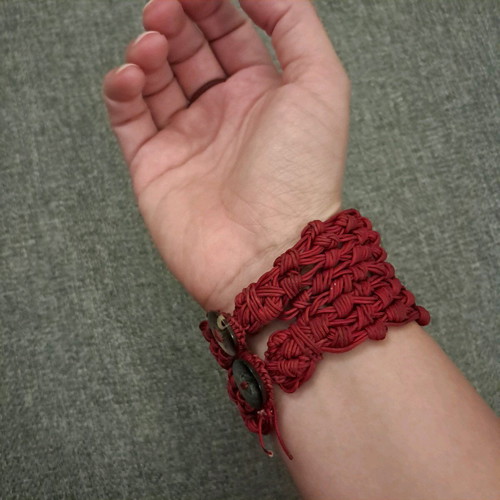 Red knitted bracelet with ring used