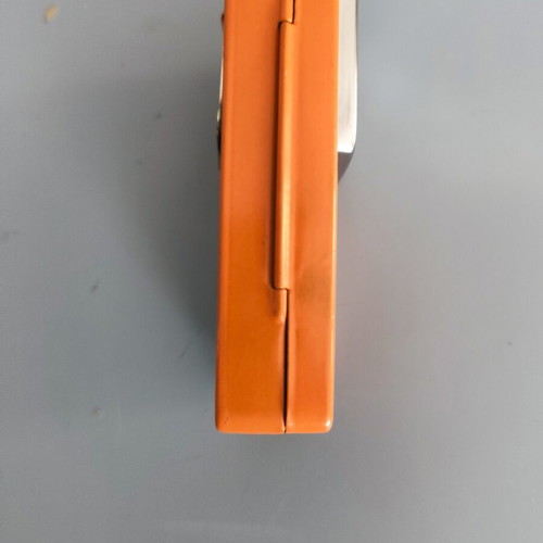 Vintage orange flat pocket flashlight used with retro UCAR battery