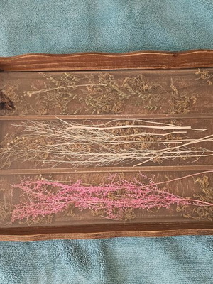 Wooden decorative serving tray used with dried flowers and glass surface