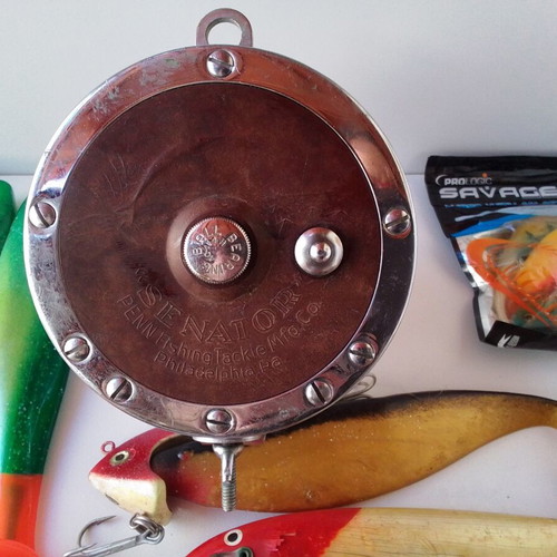 Penn Senator 114H fishing reel with large set of unused artificial lures and soft baits