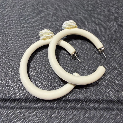 Pair of off-white matte resin hoop earrings with fabric floral accents