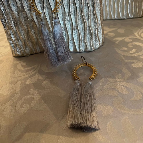 Dangling earrings used with grey tassels and gold details