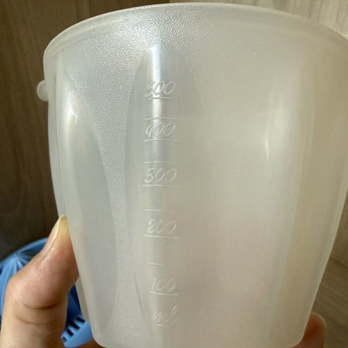 Plastic handheld citrus juicer with measuring container