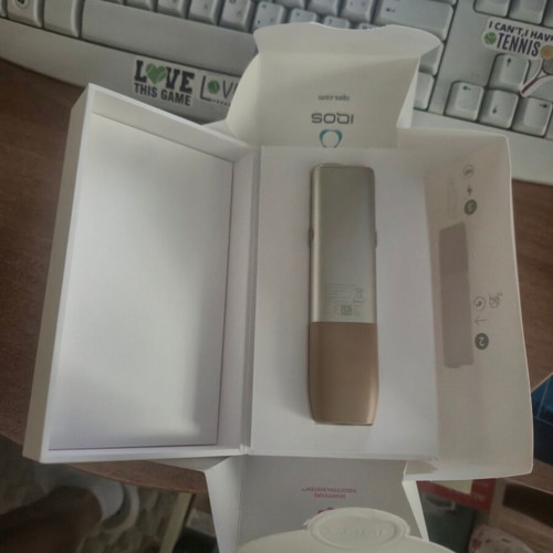 Iqos ILUMA One Gold device used with box and cable