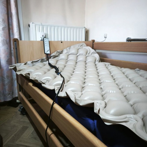 Electric hospital bed with wooden frame, pressure relief mattress and pump
