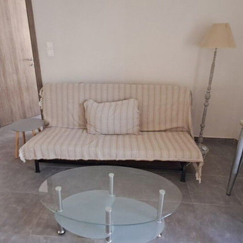IKEA sofa bed, modern floor lamp, glass coffee table