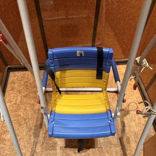 Children's swing with seat and safety straps used
