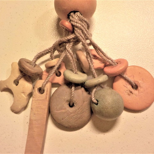 Long handmade earrings made of wood and cord in pastel colors