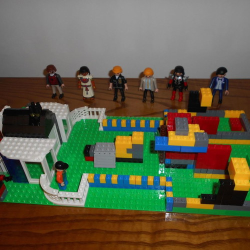 Building toy with Lego bricks and 6 Play Mobil figures used