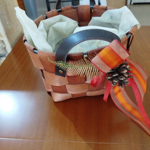 Wooden woven gift basket with leather handles, used