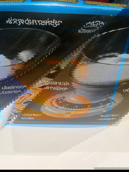 Ζυγαριά κουζίνας καινούργια στο κουτί της κίτρινου χρώματος.