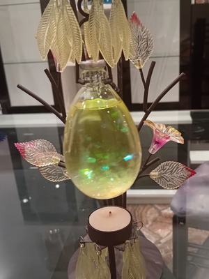Decorative candle holder with metal tree base, used