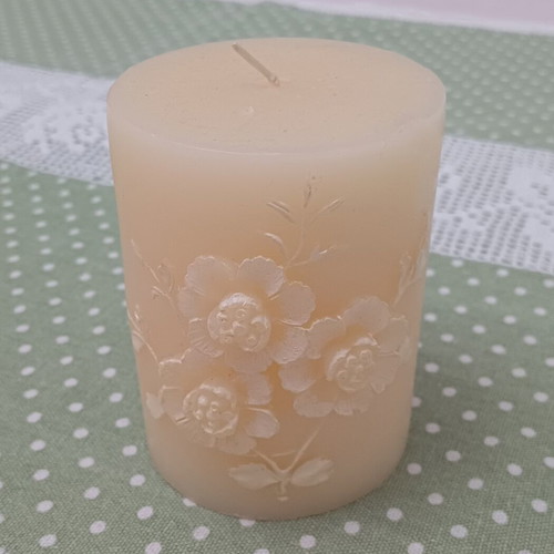 Decorative candle with embossed floral design like new, cream color