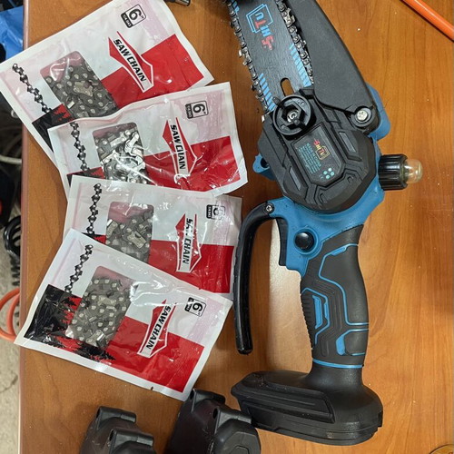 Battery-powered chainsaw with 2 batteries, charger, 5 chains, and oil bottle