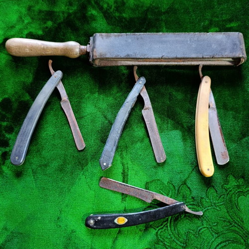 Vintage straight razors with leather strop and wooden handle