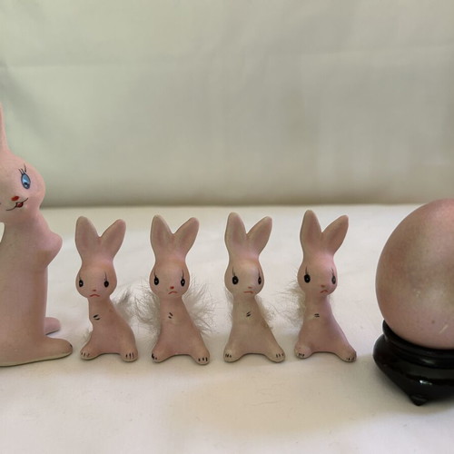 Vintage ceramic pink bunny family figurines with decorative Easter egg