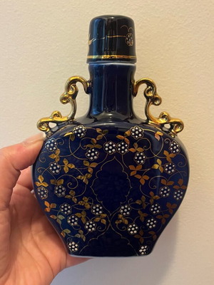 Decorative antique bottle made of blue glass with gold details like new
