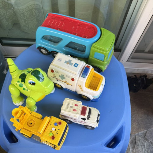 Various toys including vehicles and dinosaur