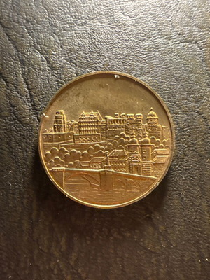 Collectible metal souvenir medal with embossed castle design