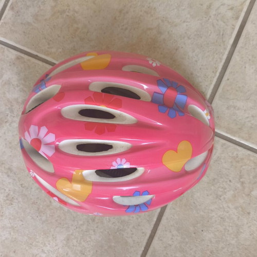 Pink bicycle helmet with flower and heart design