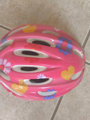 Pink bicycle helmet with flower and heart design