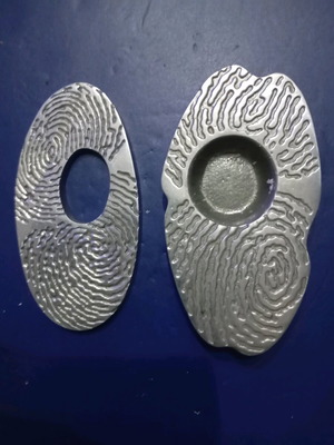 Two used aluminum micro sculptures with fingerprint theme