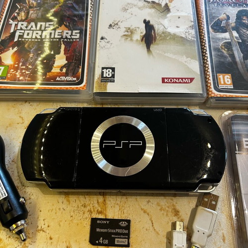 Sony PSP-2004 console with 8 game cartridges and accessories set
