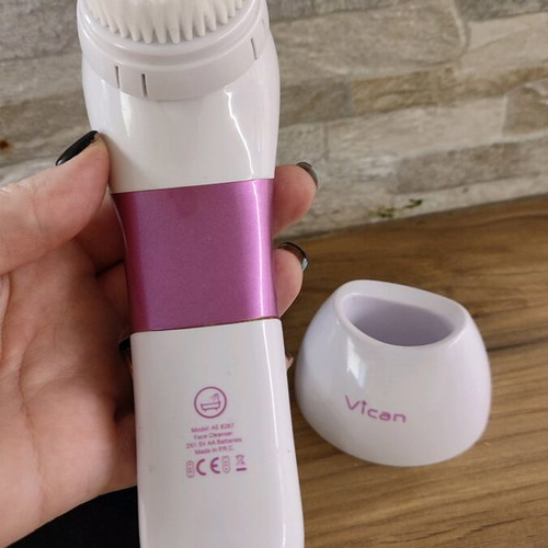 Facial cleansing device used with two heads and stand