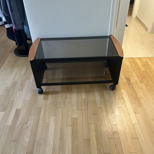 Coffee table with glass top, black metal frame and wooden corners