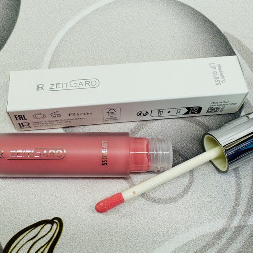 Lip gloss with long-lasting volume and glossy pink finish