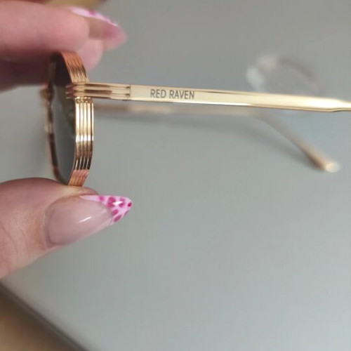 Red Raven sunglasses with gold frame, black lenses