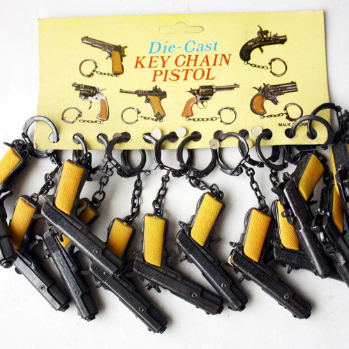 Card with 12 vintage 80's Colt 45 metal pistol keychains new