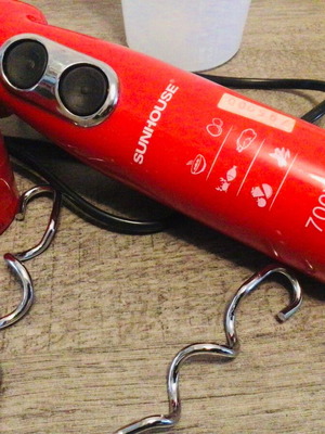 Electric egg beater used with container and dough mixing attachments