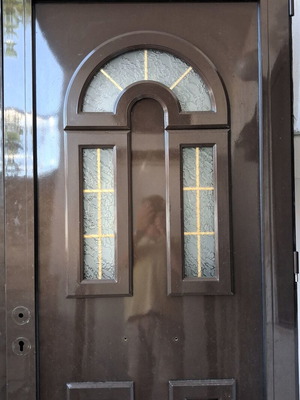Two brown aluminum entrance doors with frames, handles, and locks