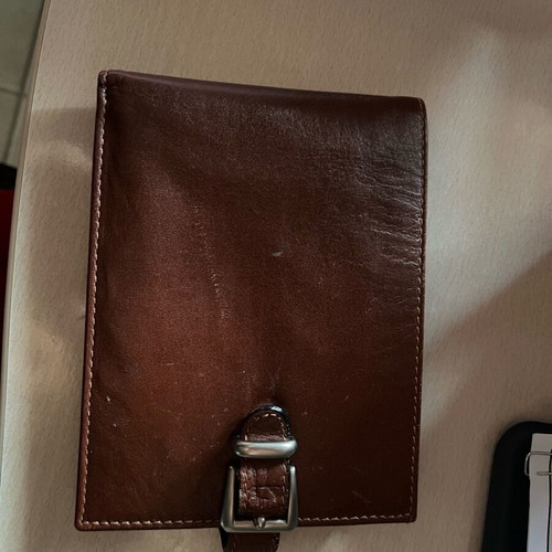 Brown wallet used with multiple card slots and belt-style clasp