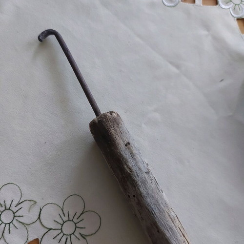Vintage tool used, wooden part damaged, likely screwdriver
