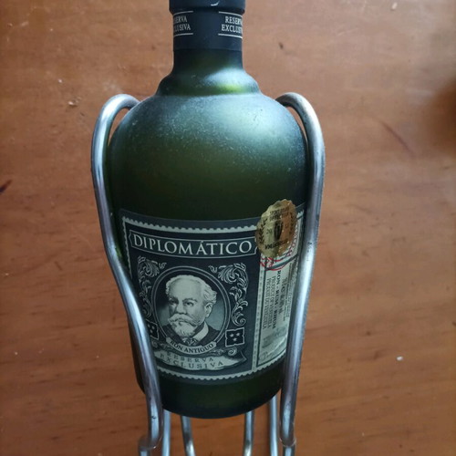 Bottle holder stainless like new with collectible rum bottle