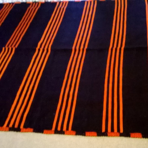 Woven blanket used orange and blue in two joined pieces