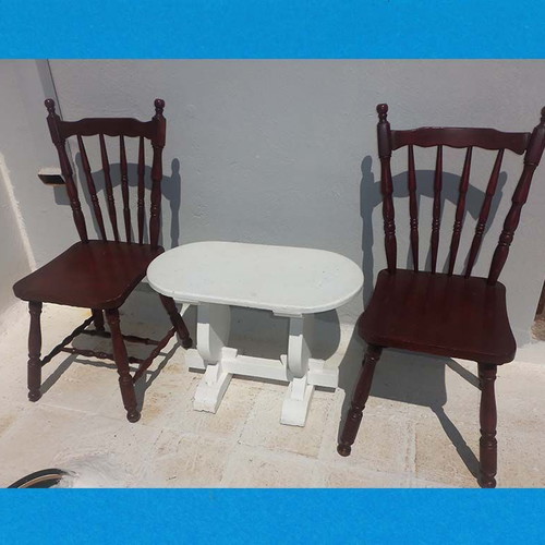 Wooden set with oval white table and 2 traditional dark chairs used for outdoor