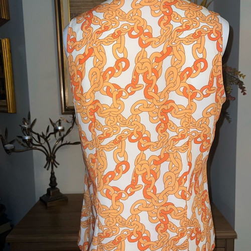 Blouse like new with white and orange chain pattern, size M