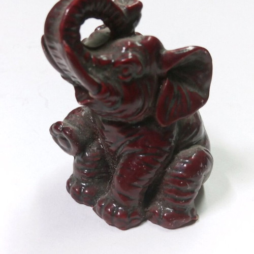 Carved miniature laughing elephant statue like new, burgundy color