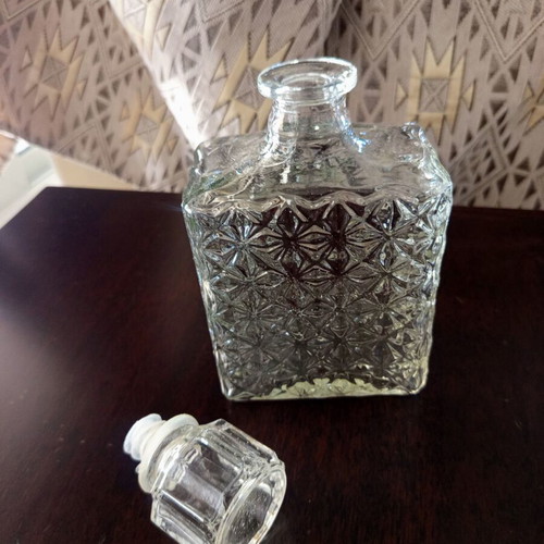 Vintage glass decanter with embossed geometric design and stopper