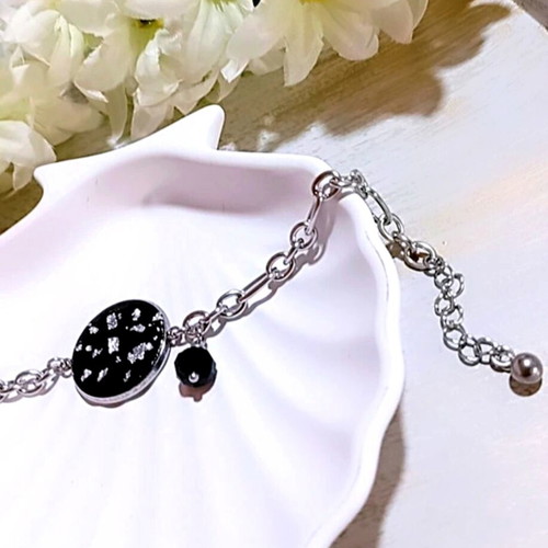 Handmade steel bracelet with iridescent black motif and silver flakes