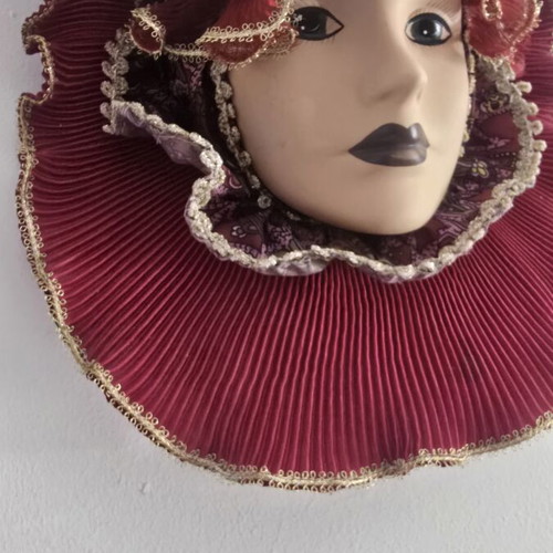 Decorative porcelain wall mask used with fabric hat in burgundy