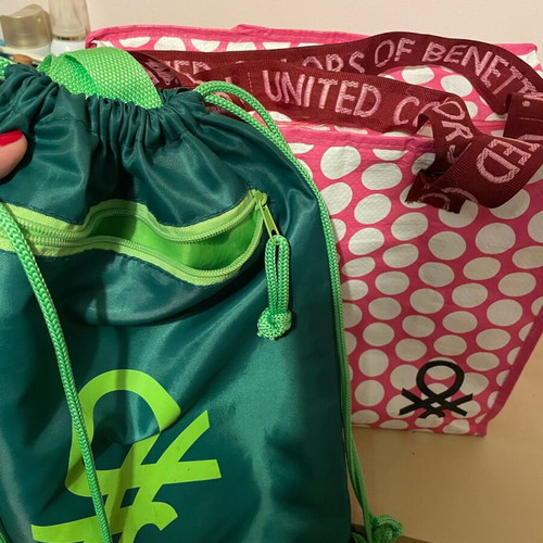 Benetton travel accessory set with pink shoulder bag and green drawstring backpack