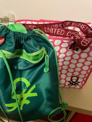 Benetton travel accessory set with pink shoulder bag and green drawstring backpack