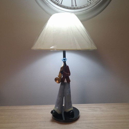 Table lamp with jazz player on plexiglass base and beige shade